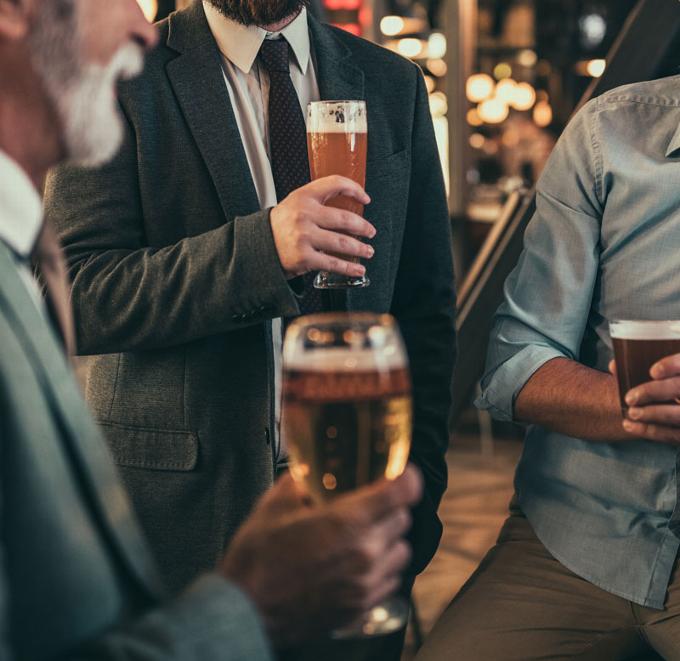 men in suits in pub drinking beer